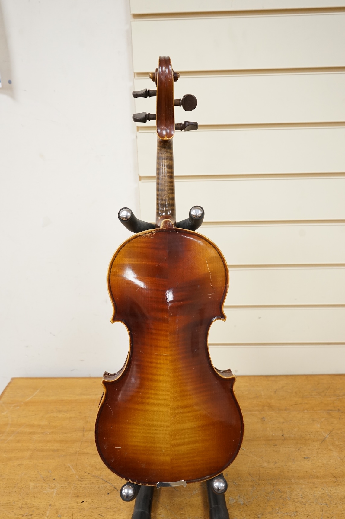 Five cased 20th century violins, including; a German violin, two Czech violins, a three-quarter size violin with a label for Bienfait, and a Romanian quarter size violin, all in cases or the remains of cases.
